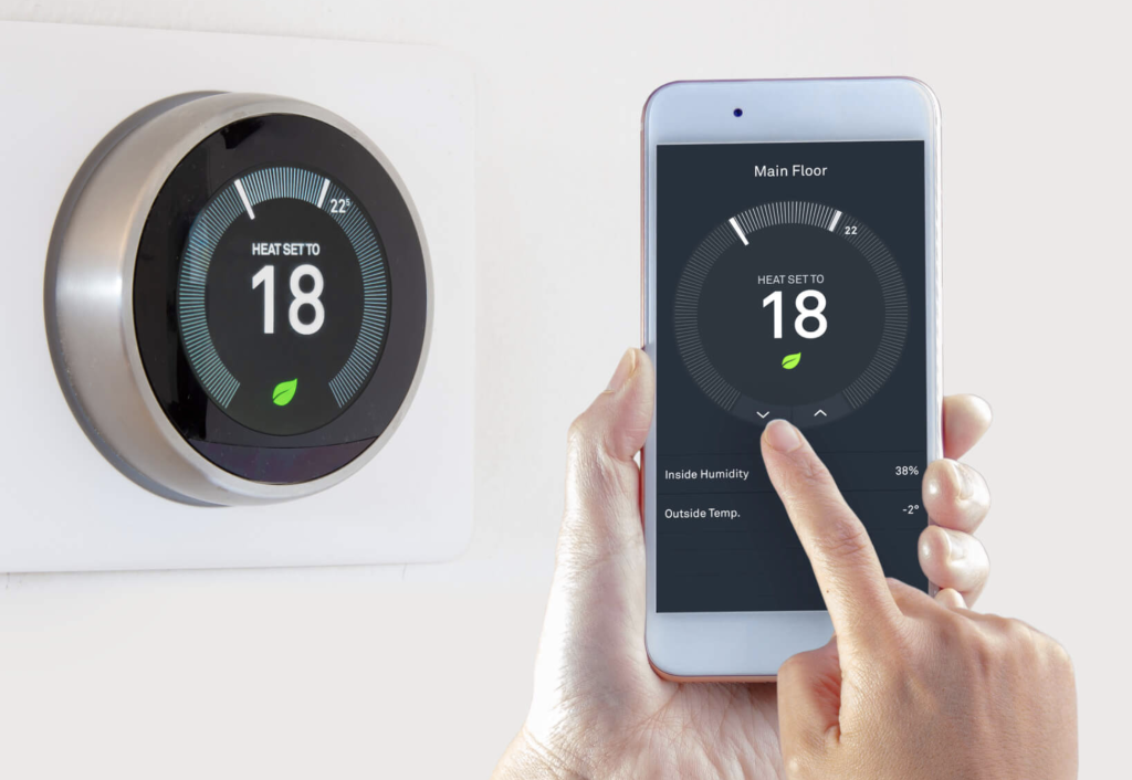 Woman pushing button on digital thermostat at house